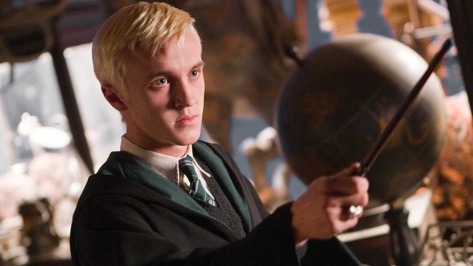 Draco holds out his wand in Harry Potter.