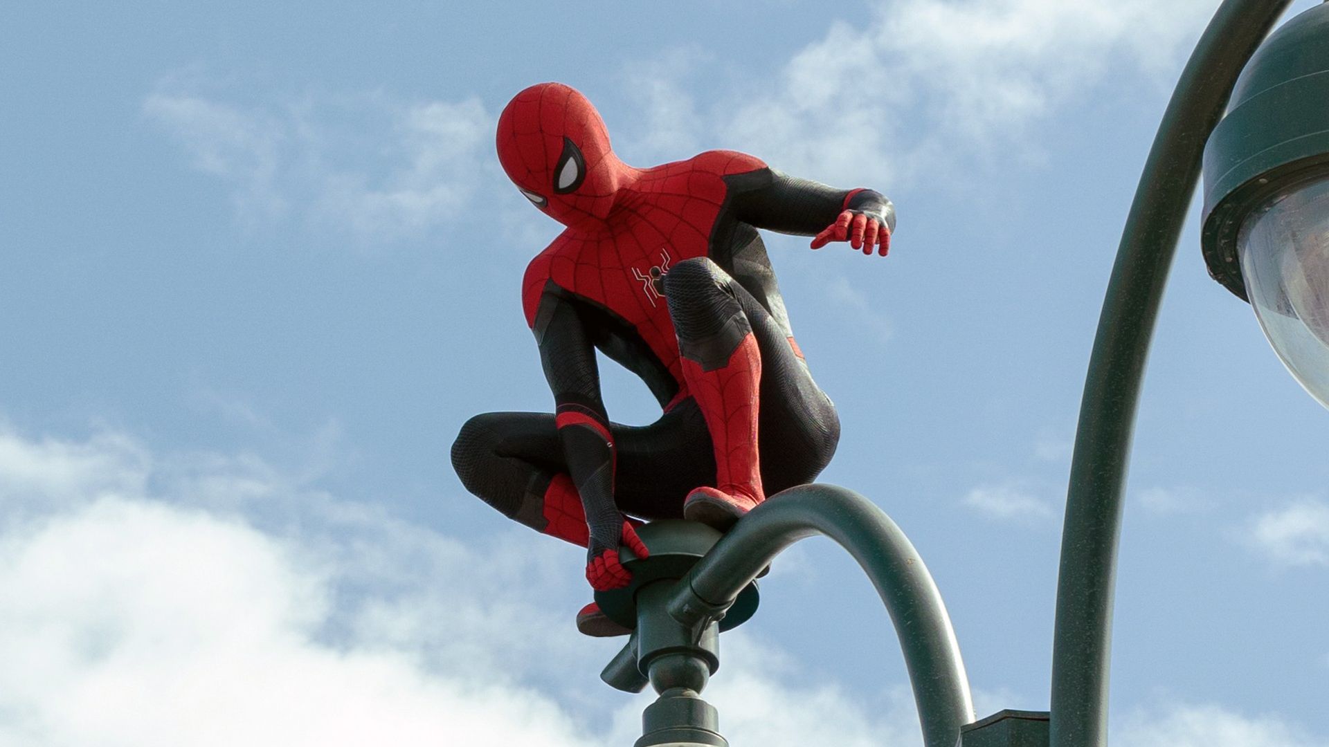Spider-Man (Tom Holland) perches on a lamppost in the MCU