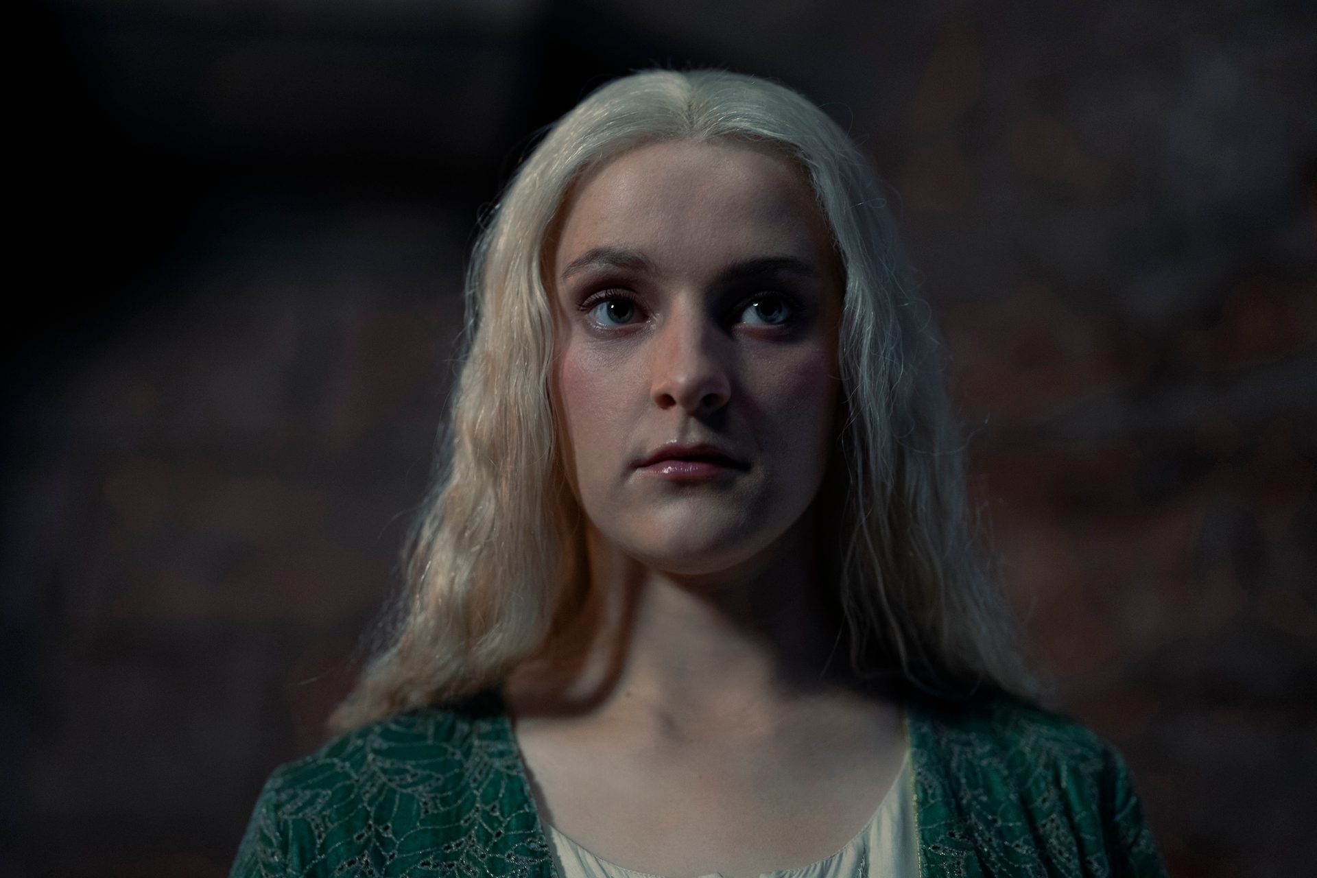 Phia Saban stands in close-up as Queen Helaena Targaryen with her hair down in House of the Dragon season 2.