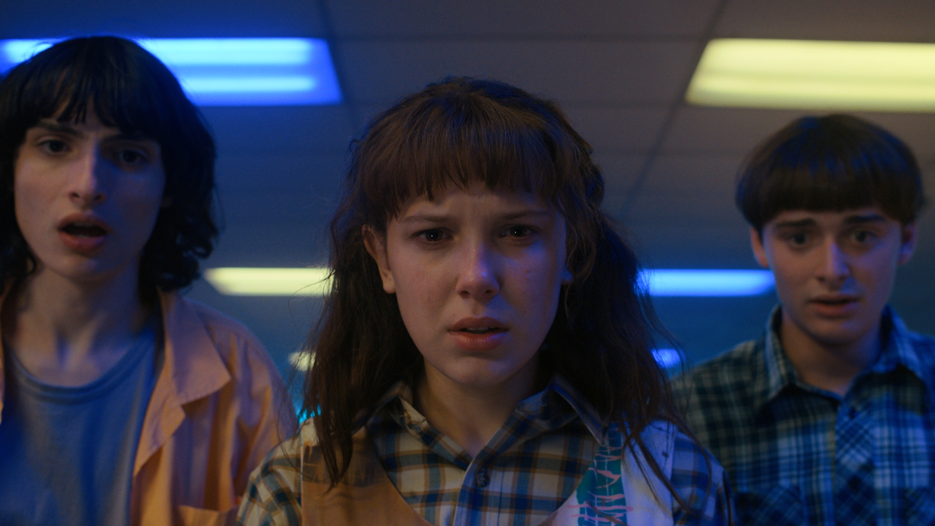 Finn Wolfhard as Mike, Millie Bobby Brown as Eleven, and Noah Schnapp as Will in Stranger Things season 4